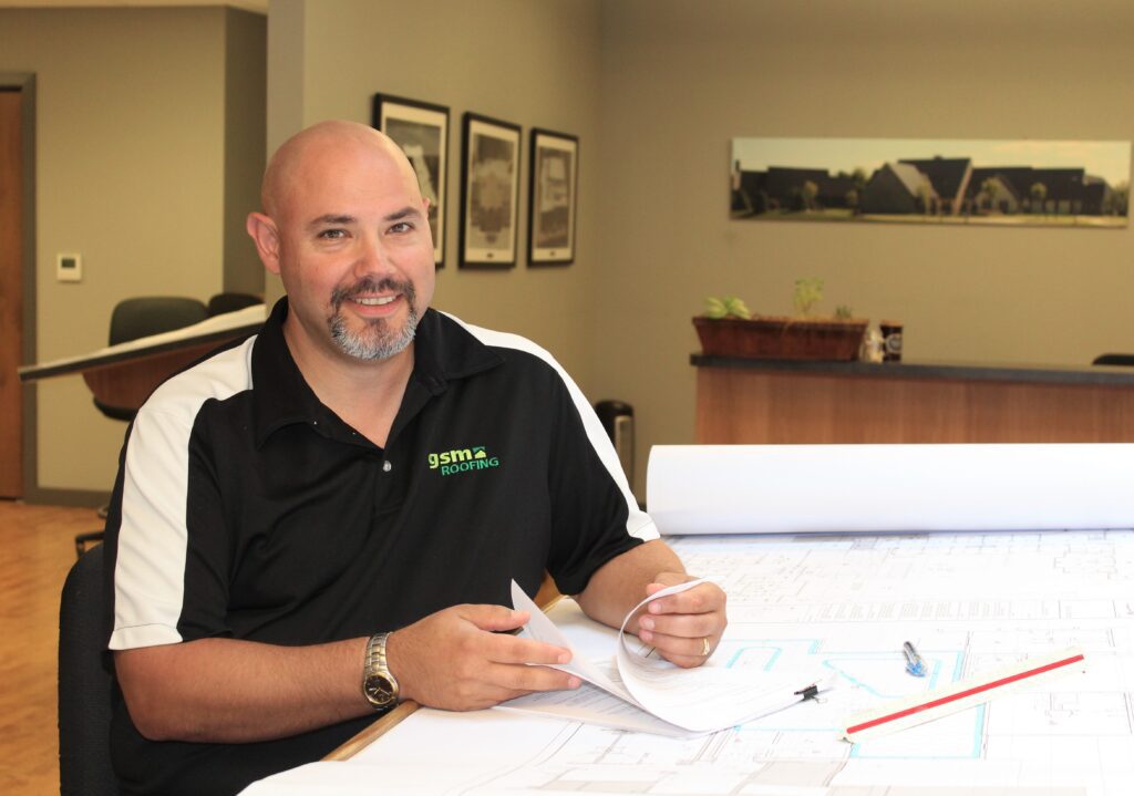 Roofing employee holding plans