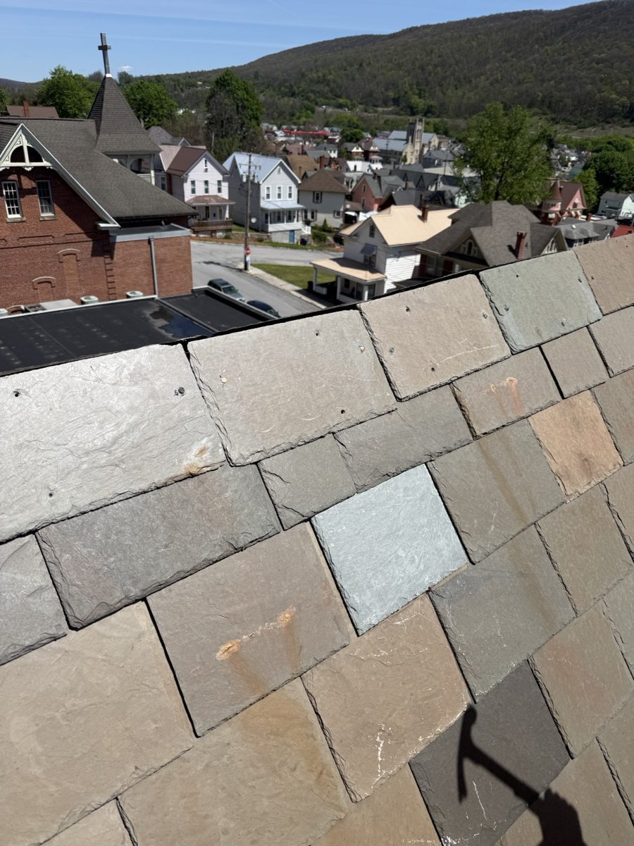 Completed Vermont Gray slate roof restoration at St. Matthew Roman Catholic Church Tyrone PA Blair County with Tyrone Pennsylvania townscape and Blair County ridge in background by GSM Roofing historic slate specialists 2026